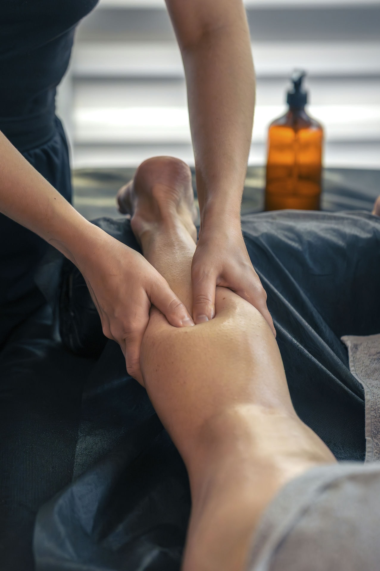 vertical_0002_masajear-las-piernas-en-la-mesa-con-aceite-golpes-suaves-para-la-ligereza